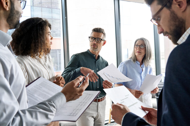 Multietnic business executive team having discussion at office meeting. Multiethnic business executive team having discussion at office meeting. Diverse multiracial corporate leaders group brainstorming analyzing project financial result in board room developing strategy.