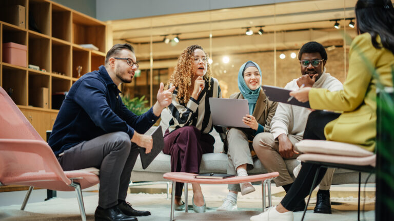 Wide Shot of a Multiethnic Group of People Discussing Ideas in a Meeting Room at Office. Businesspeople Making Creative Decisions For their Startup and Discussing Options
