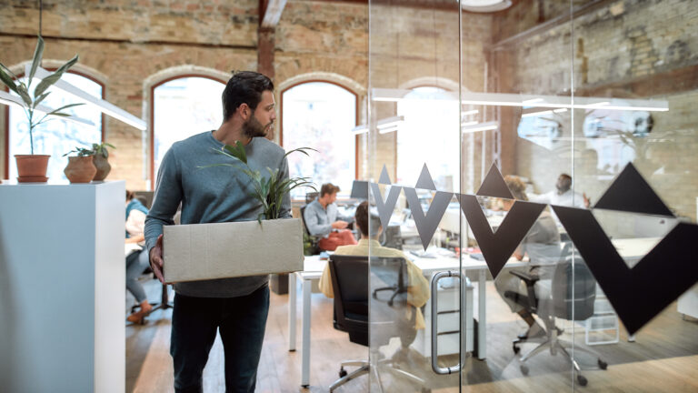 Saying good bye. Handsome man in casual wear holding box with personal things and leaving modern office Saying good bye. Handsome man in casual wear holding box with personal things and leaving modern office. Quit concept. Office life
