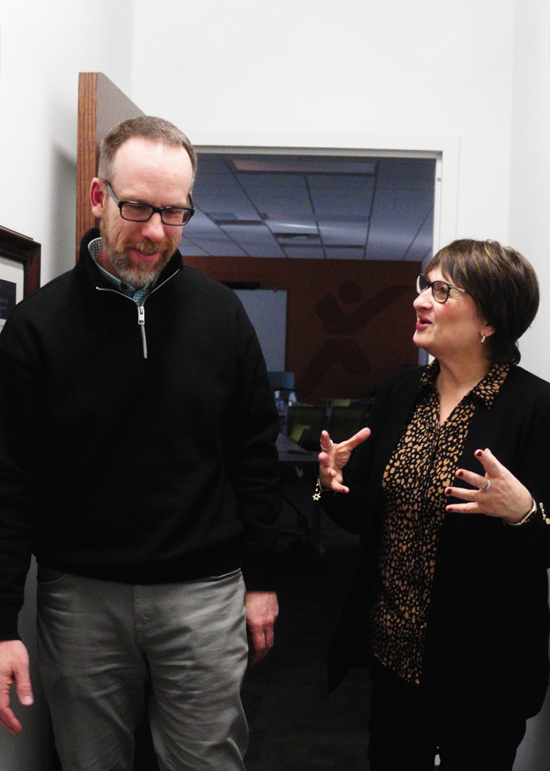 Two professional facilitators walking down the hall in an engaging conversation